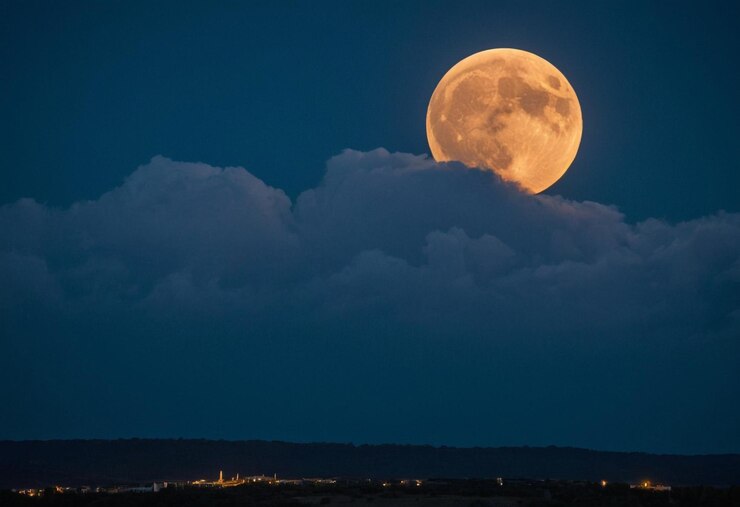 una luna llena se levanta en el cielo nocturno