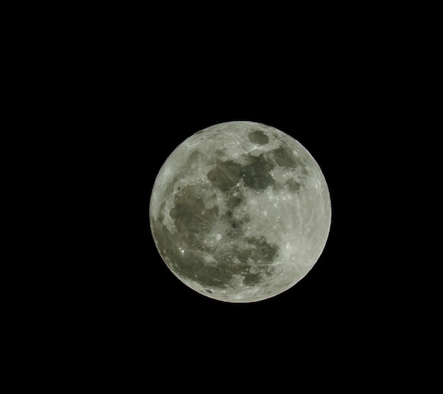 Foto luna llena sobre el oscuro cielo negro en la noche