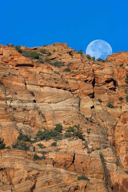 Foto luna puesta sobre acantilados del suroeste