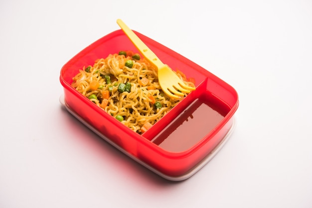 Lunch Box o Tiffin para niños indios, contiene fideos calientes con verduras frescas junto con salsa de tomate. enfoque selectivo