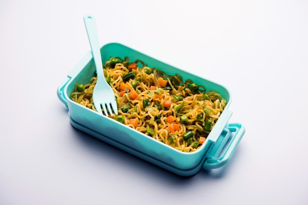 Lunch Box oder Tiffin für indische Kinder, enthält heiße Nudeln mit frischem Gemüse zusammen mit Tomatenketchup. selektiver Fokus