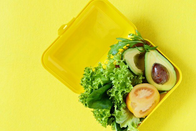 Lunchbox mit einem Snack aus Kräutern und Avocado