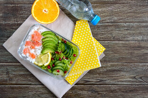 Lunchbox-Reis-Lachs-Salat mit Gurken-Avocado-Grüns-Zitrone-frischem Orangenwasser