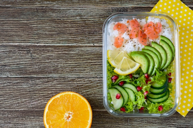 Lunchbox-Reis-Lachs-Salat mit Gurken-Avocado-Grüns-Zitrone-frischem Orangenwasser