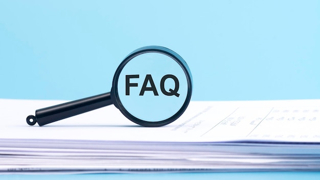 Lupa com inscrição de perguntas frequentes do FAQ em um fundo azul