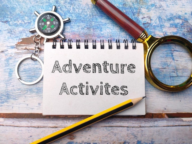 Lupa y cuaderno con la palabra Actividades de Aventura