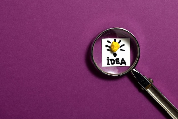 Lupa de conceito de ideia criativa e ícone de lâmpada com fundo roxo