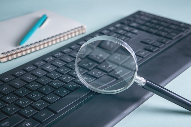 Foto lupa de conceito de pesquisa na internet e teclado de computador