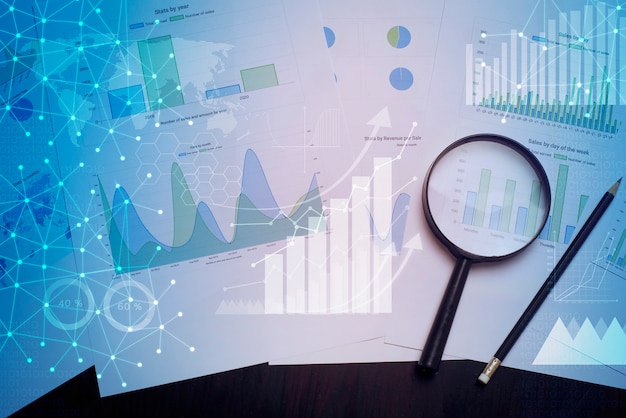 Lupa y documentos con datos analíticos sobre la mesa