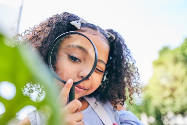 Foto lupa e folhas de menina no jardim, quintal ou parque em estudo de ciências ou ao ar livre lente de criança jovem e zoom para pesquisa da natureza ou verificação de ecologia ou crescimento de plantas no verão