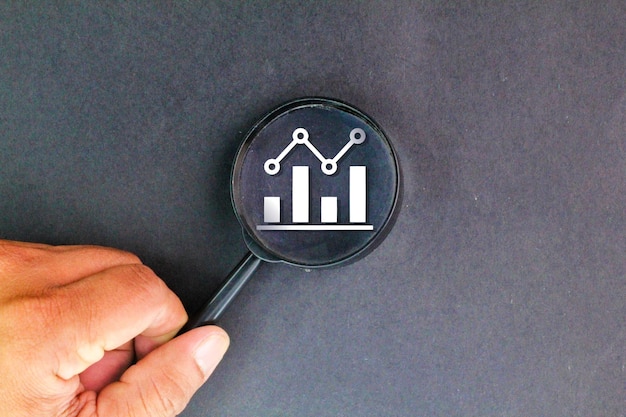 lupa y gráfico comprobación de los informes financieros gráficos y gráficos simboliza el enfoque a