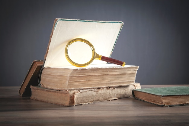 Lupa con libro sobre la mesa.