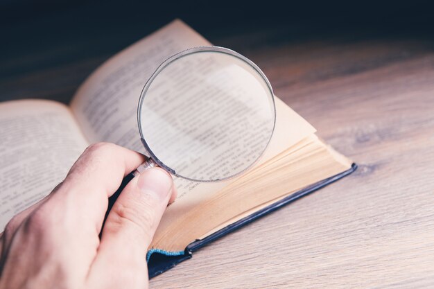 Lupa y libro sobre la mesa.