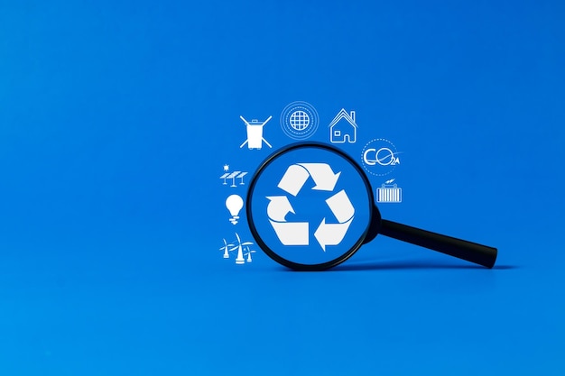Una lupa que muestra un símbolo de reciclaje con un fondo azul para expresar conceptos relacionados