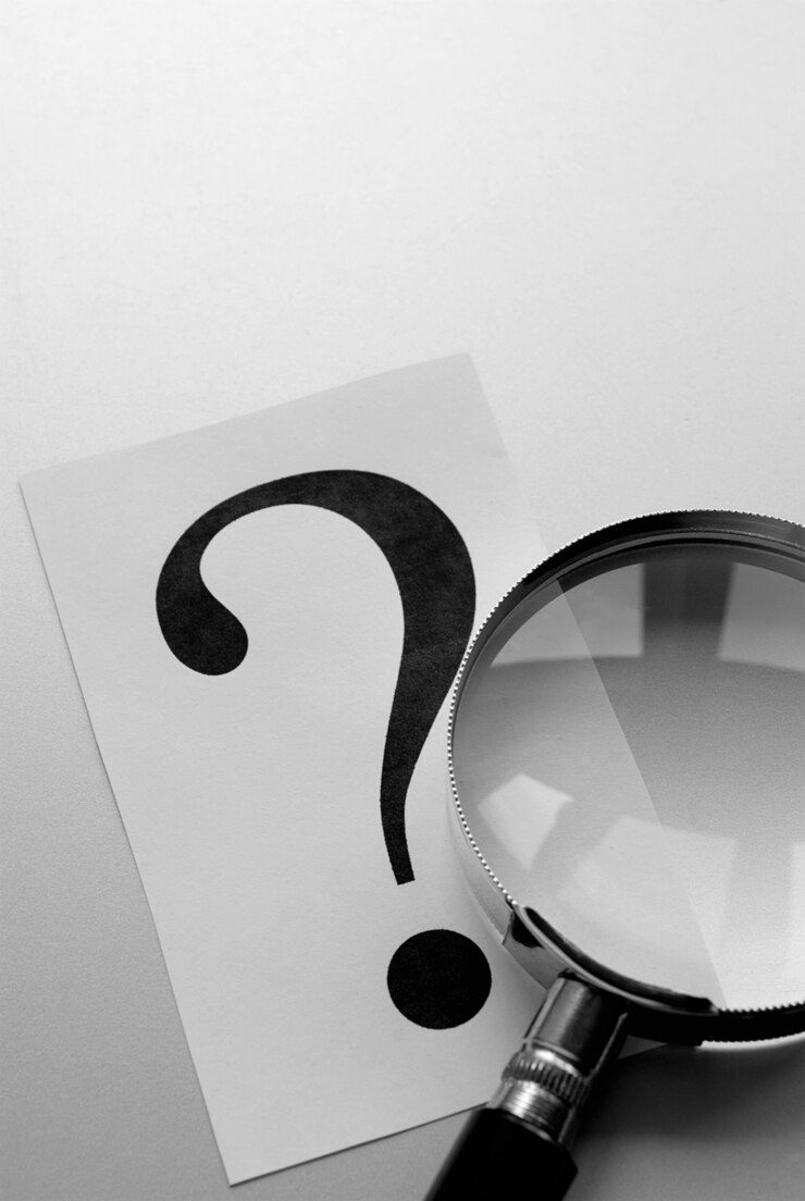 Foto lupa y un signo de interrogación en el papel.
