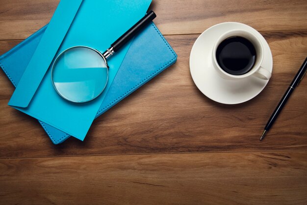 Lupe auf Brief und Tasse Kaffee auf dem Tisch