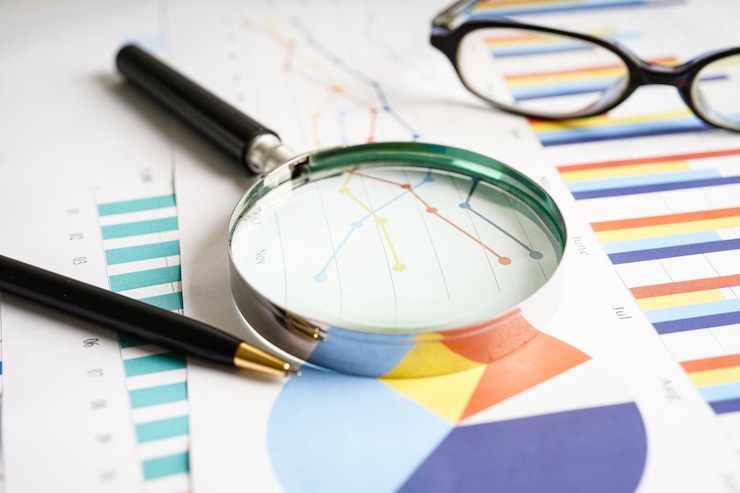 Foto lupe auf diagrammen diagrammpapier finanzielle entwicklung bankkonten statistiken investitionen analytische forschungsdaten wirtschaft