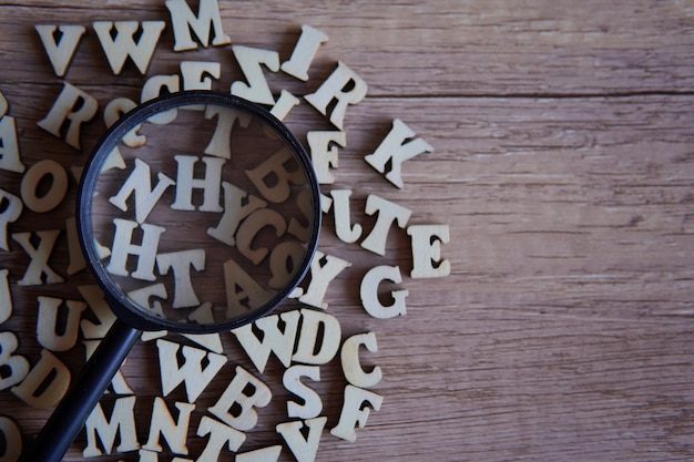 Lúpula com letras do alfabeto espalhadas sobre a mesa Espaço de cópia para texto Conceito de educação