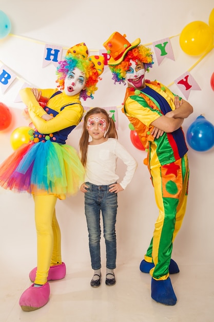 Lustige Clowns im Urlaub zeigen ihre guten Gefühle mit einem Mädchen