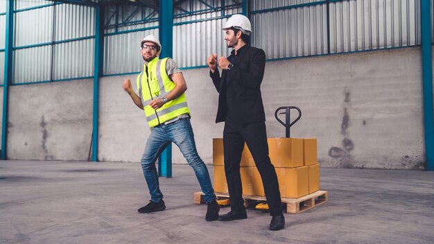 Lustige Fabrikarbeiter tanzen in der Fabrik