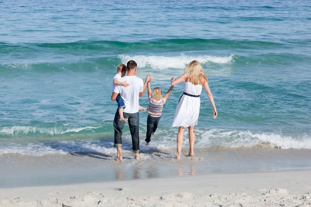 Lustige Familie, die auf den Sand geht