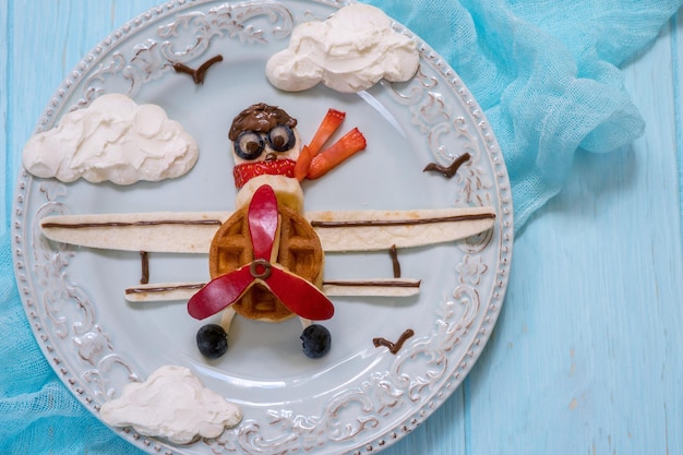 Lustige Flugzeug-Frühstückswaffel mit Früchten für Jungenkinder