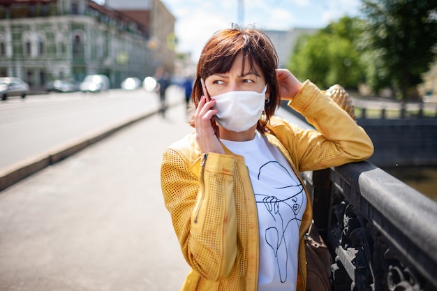 Lustige Frau mittleren Alters in einer weißen Schutzmaske