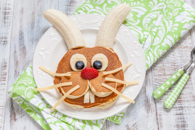 Lustige Häschenpfannkuchen mit Früchten für Osterkinderfrühstück