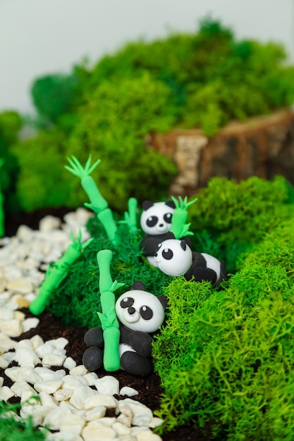 Lustige hausgemachte Plastilin-Pandas in einem stilisierten Dschungel Konzept für den Welttiertag Panda-Tag Tag der Erde Umweltschutz