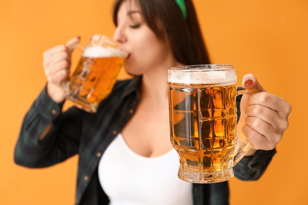 Foto lustige junge frau mit bier. feier zum st. patrick's day