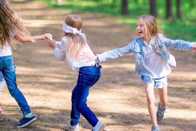 Lustige Mädchen spielen Blindekuh draußen im Wald