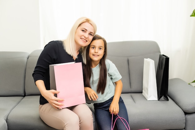 Lustige Mutter und ihre Tochter haben nach dem Einkaufen Spaß zu Hause