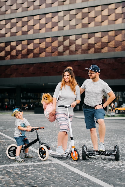 Lustige Sommerzeit mit der Familie. Wir fahren Segway, Roller und Fahrrad mit einem kleinen Spitzhund.