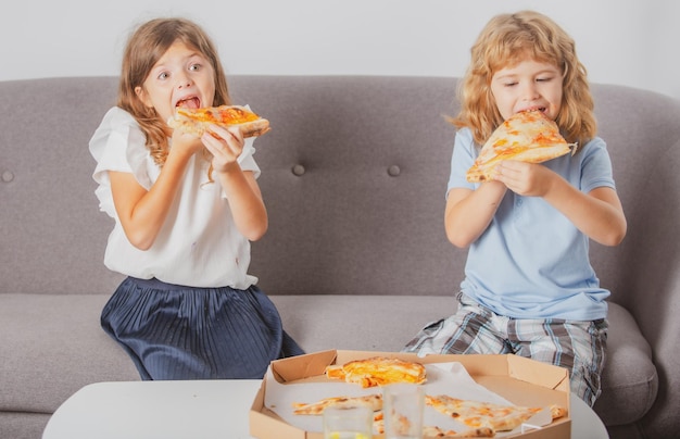 Lustige süße Kinder Mädchen und Jungen essen leckere Pizza hungrige Kinder essen Pizza