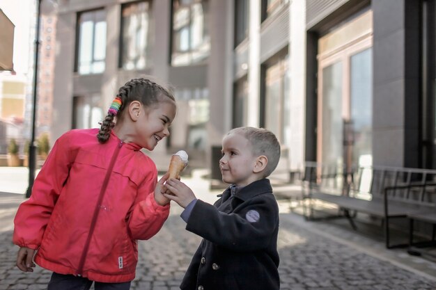 Lustige Süßigkeiten Mädchen genießen süßes Dessert und teilen es mit ihrem Bruder Street Food außerhalb des Lebensstils