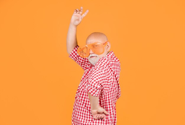 Foto lustiger älterer mann oder großvater mit partybrille auf gelbem hintergrund