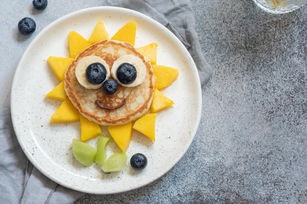 Lustiger Blumenpfannkuchen mit Fruchtfrühstück