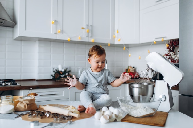 Lustiger Familienfreudiger Junge, der den Teig vorbereitet, Kekse in der Küche backen