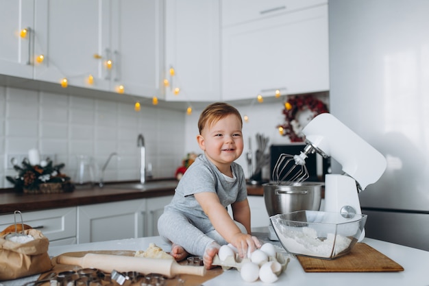 Lustiger Familienfreudiger Junge, der den Teig vorbereitet, Kekse in der Küche backen