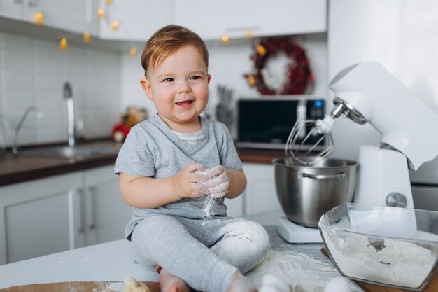 Lustiger Familienfreudiger Junge, der den Teig vorbereitet, Kekse in der Küche backen