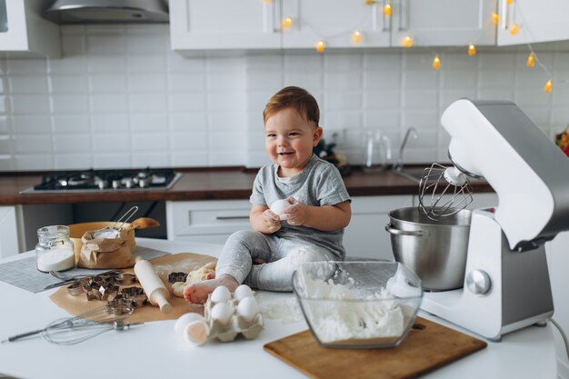 Lustiger Familienfreudiger Junge, der den Teig vorbereitet, Kekse in der Küche backen