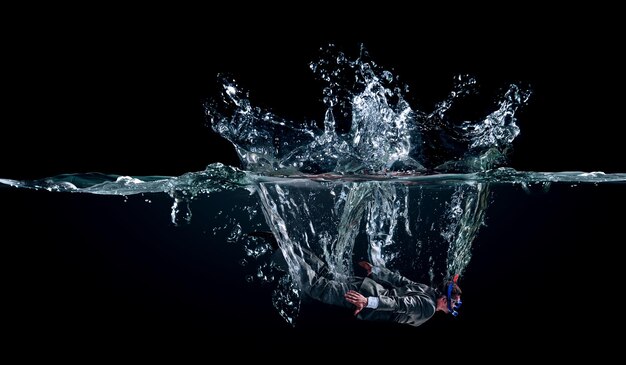 Lustiger Geschäftsmann, der unter Wasser schwimmt. Gemischte Medien