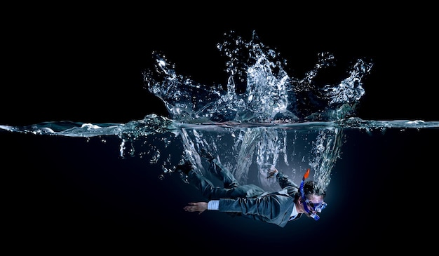 Lustiger Geschäftsmann, der unter Wasser schwimmt. Gemischte Medien