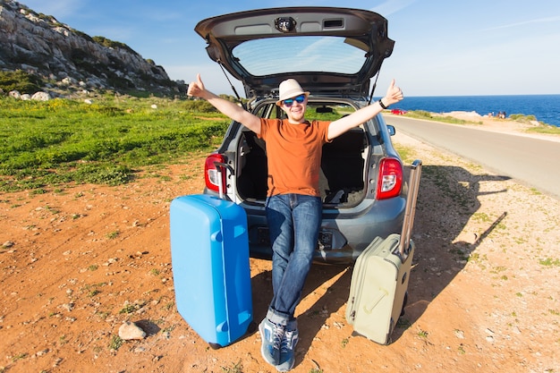 Lustiger glücklicher Mann, der in die Sommerferien geht. Autoreisekonzept.