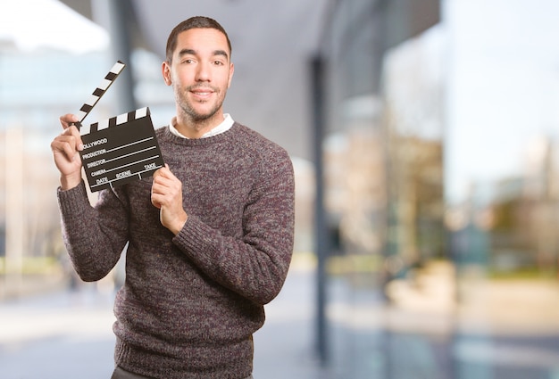 Foto lustiger junger mann mit einem clapperboard