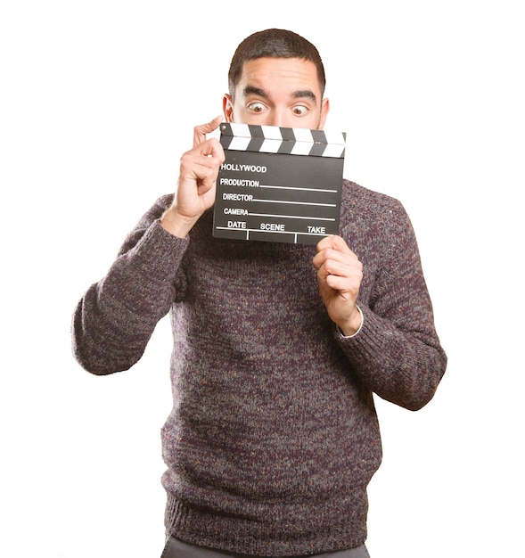 Lustiger junger Mann mit einem clapperboard