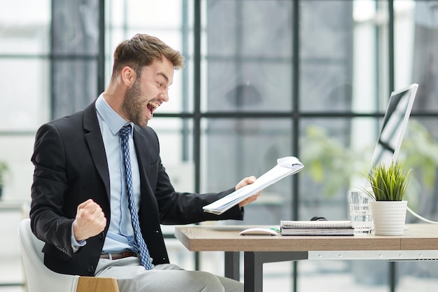 Lustiger männlicher Angestellter hat Spaß an der Leistung des Siegers im modernen Büro