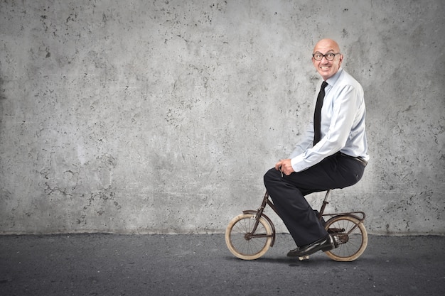 Lustiger Mann auf einem winzigen Fahrrad