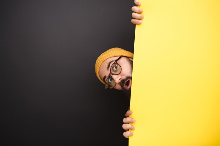 Lustiger Mann, der hinter dem gelben Banner hervorschaut