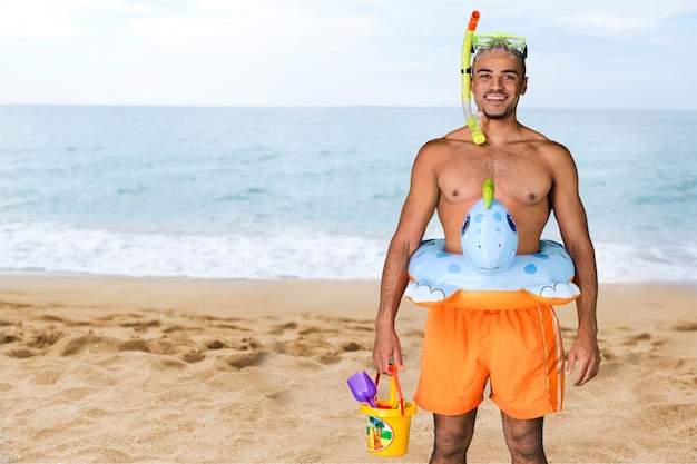 Lustiger Mann Tourist voller Strandzubehör